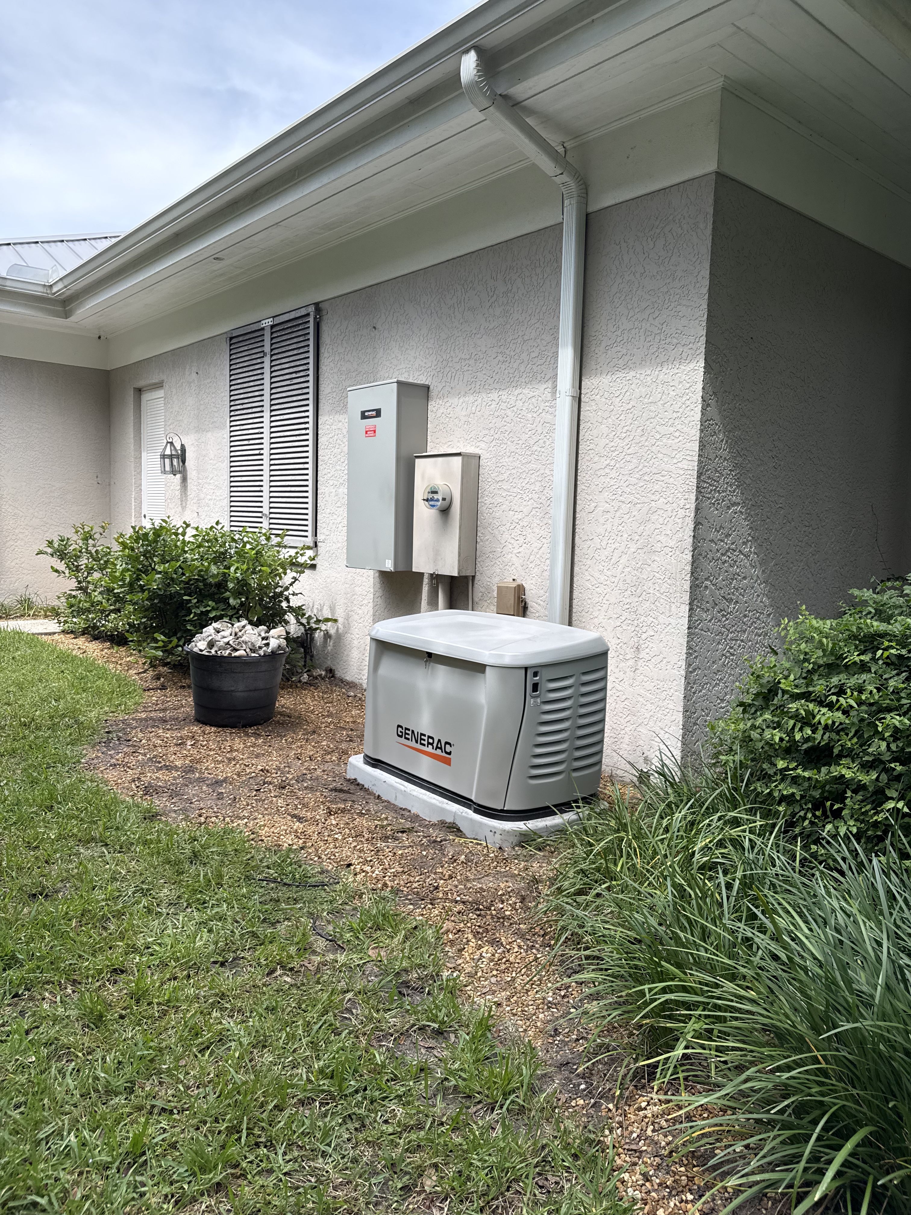 Generac generator installed on a pad beside a house